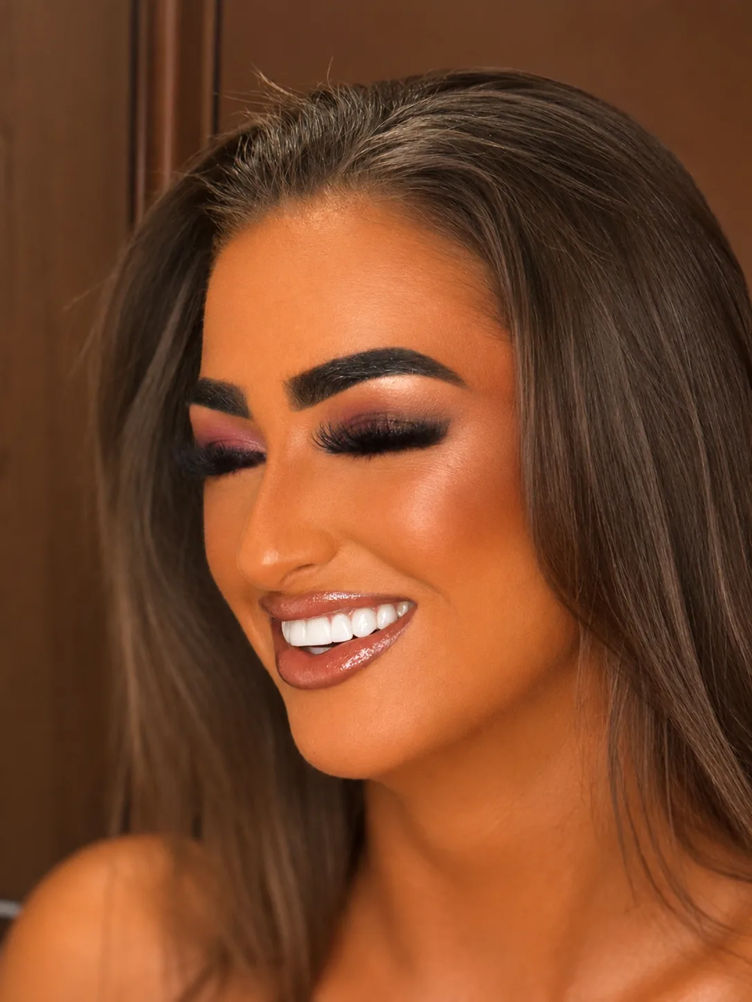 Full glam party makeup smiling - dark smoky eye, bronzed contour and glossy nude lip by MZ Makeup